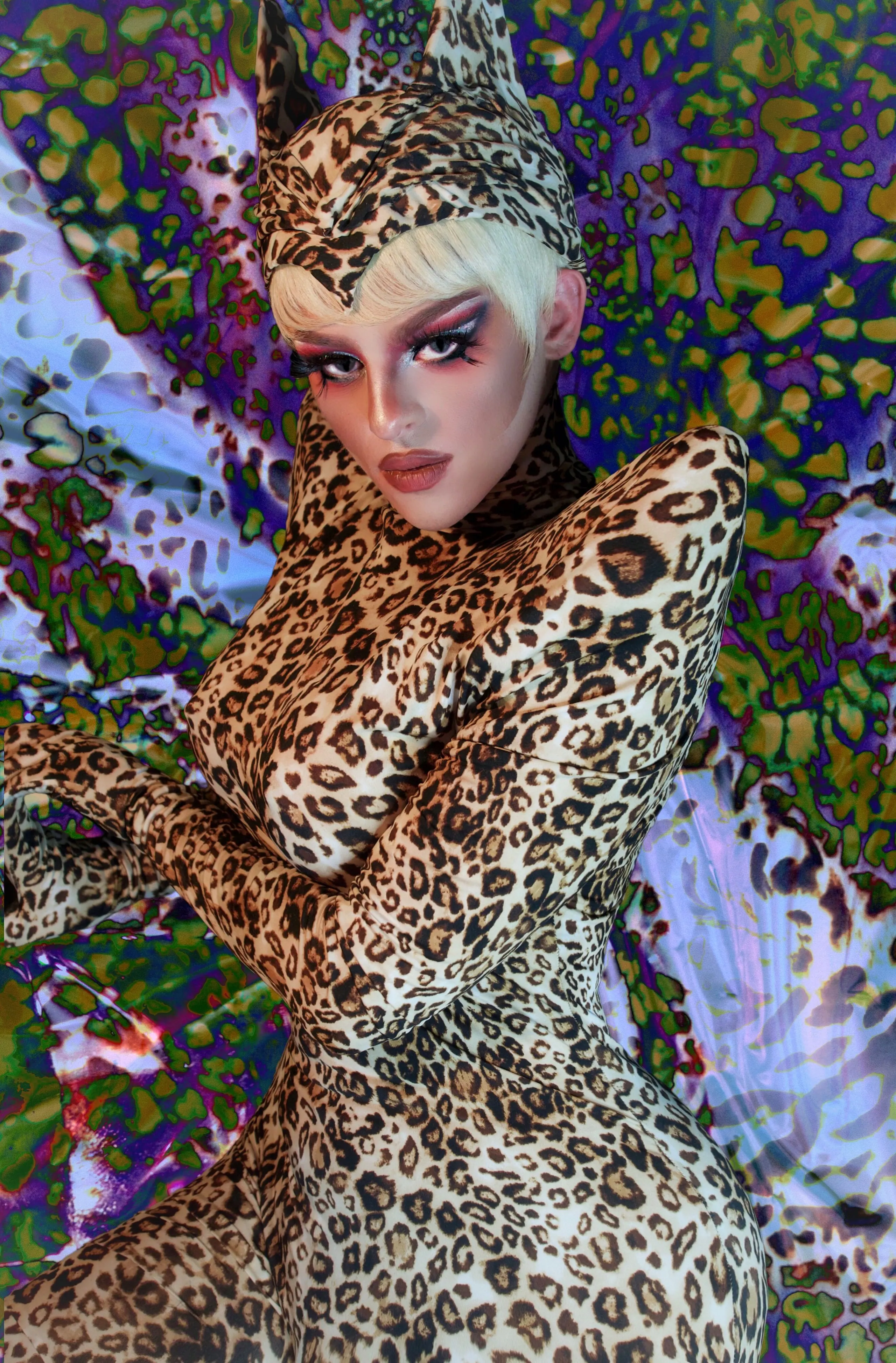 Leopard catsuit with matching hood against a psychedelic leopard backdrop