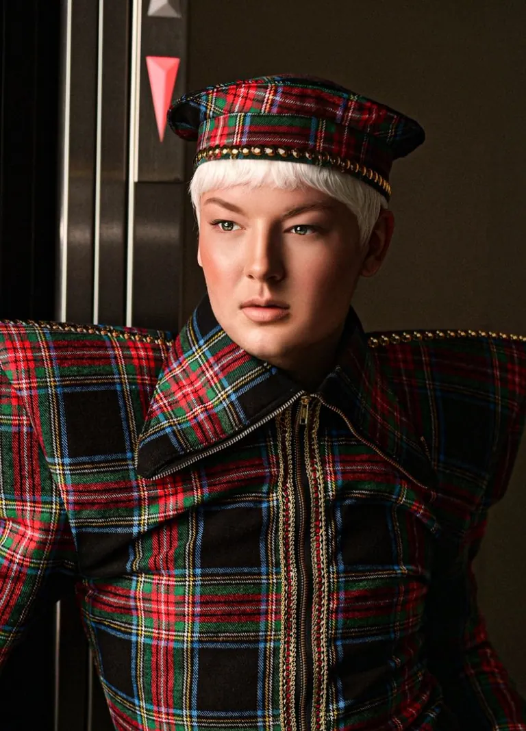 Close portrait in a tartan jacket with a large collar and a matching tartan cap