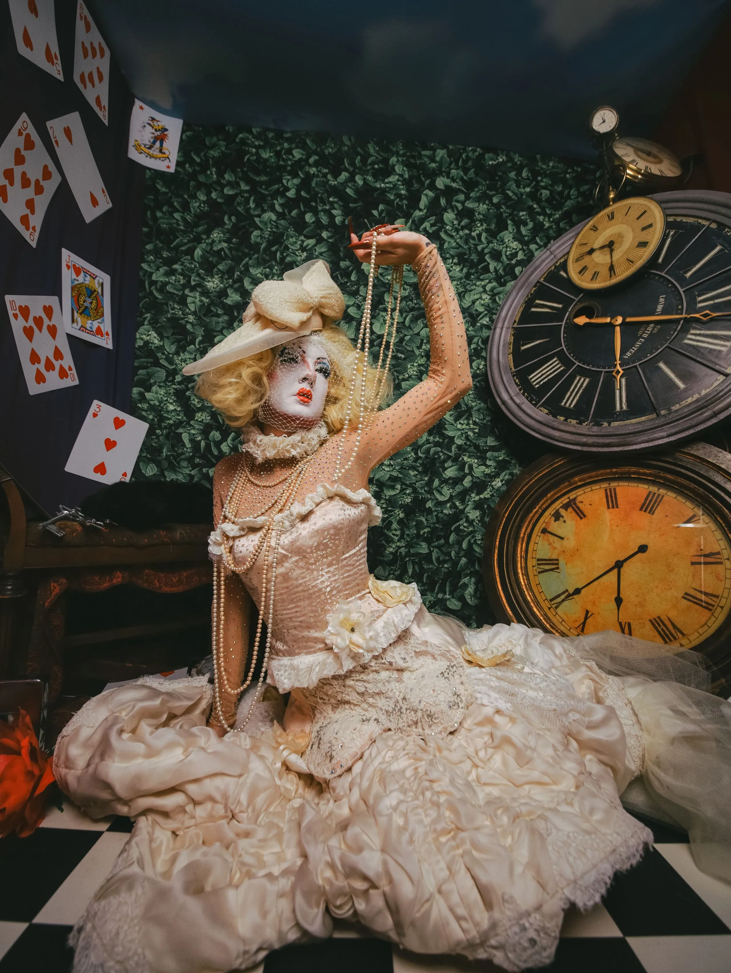 The ivory gown pooled on the floor, a string of pearls held up to the light